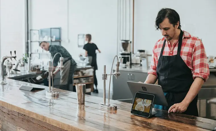 Atención en el mostrador de un negocio, registrando una venta en una tablet